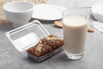 Hot fresh milk in transparent glass on gray background