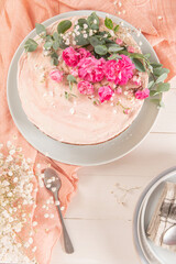 Chocolate naked cake with fresh roses and swiss buttercream on a white background