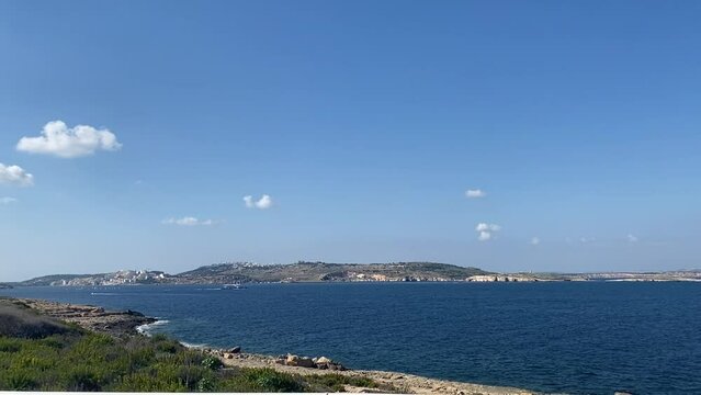Spring seascape in Qawra, Malta. Calm sea and blue sky with clouds, mediterranean island. High quality FullHD footage