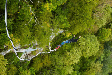 The flight of a man over the abyss on an elastic band. Jump on a ropejumping.