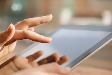 The work never stops. Shot of a woman teleworking in a cafe using a digital tablet.