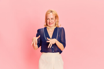 Portrait of adorable woman wearing elegant costume expressing disgusting with hands and looking...