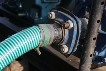 Centrifugal water pump connected to a inlet pipe with nuts and bolts to supply water for irrigation purposes