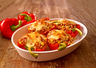 Gefüllte Ofen Paprika in weisser Auflaufform auf rustikalem Holzfond