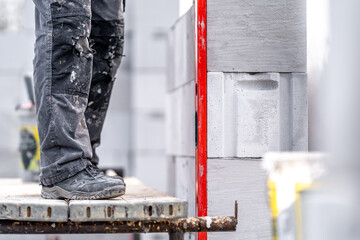 leveling bricks with the help of a spirit level during the construction of the wall of the house