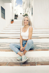 Beautiful woman is sitting at the stair case of old city 