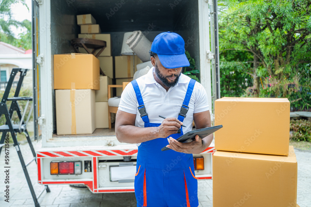 Poster moving company employee checks boxes in a small truck before sending them to the homeowner.