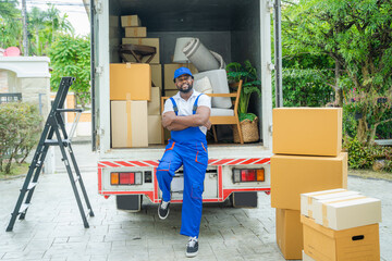 Male movers unloading boxes from van into a new home,Removal company workers,Moving house day and...