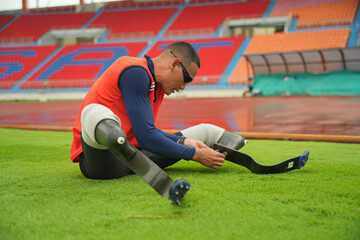 Athlete runner with prosthetic legs at track stadium