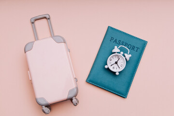 Travel luggage, international passport and alarm clock. Travel time