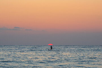 man paddling at the sunset