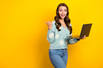 Photo of young surprised it specialist girl wear cardigan freelance hold netbook point finger mockup website jobs isolated on yellow color background