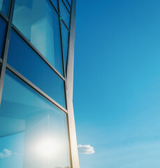 Glass windows of a modern building. Sunlight is reflected in the glass