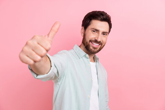 Photo portrait of attractive young man showing thumb up good quality reccomend wear trendy blue outfit isolated on pink color background