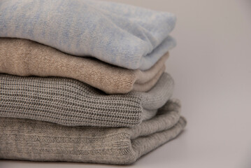 Stack of folded knitted sweaters close-up isolated on white background.close-up