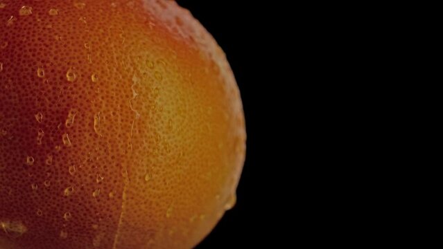 Arancia in primo piano con gocce d'acqua che scendono sopra il guscio