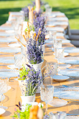 Beautiful outdoor celebration table green background with lavender decoration