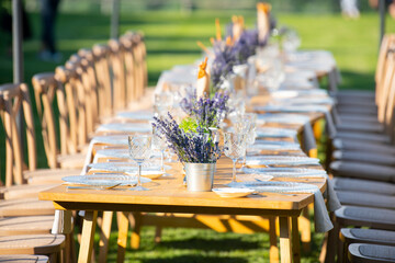 Beautiful outdoor celebration table green background with lavender decoration