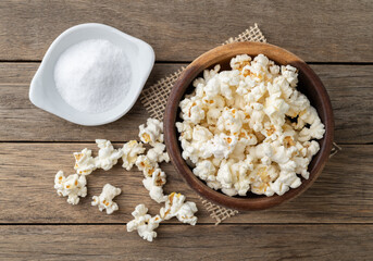 Popcorns on a bowl with salt over wooden table