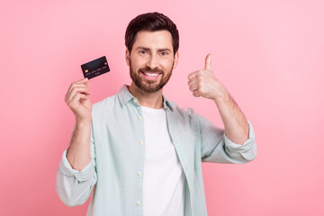 Photo of young banker promoter thumb up recommend new debit credit card wireless payment convenient service isolated on pink color background