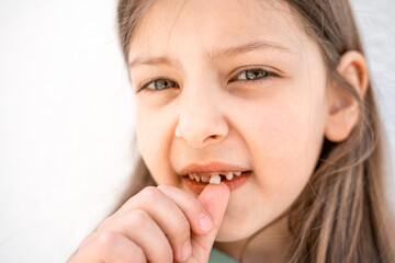 Charming smiling little girl kid with opened mouth shows staggering loose falling out first baby...