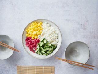 colorful poke bowl with rice, mango, cucumber and pickled red onion