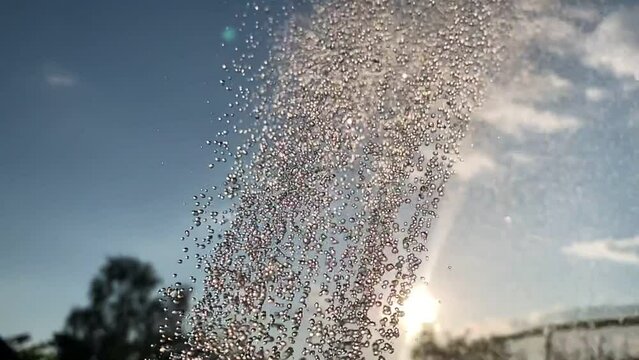 Majestic Video Animation Of Cropped Water Shower Rain Flow From Sprinkler, Air Sprayer, Pulverizer Against Trees And Blue Sky Outdoors In Countryside. Watering And Gardening. Close Up Animation