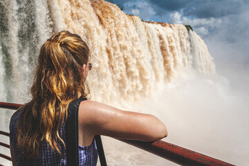 Frau am Geländer schaut auf Floriano Wasserfall,Iguazu Nationalpark,Brasilien