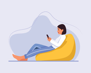  light-skinned girl with short hair sits on a bean bag chair with a phone