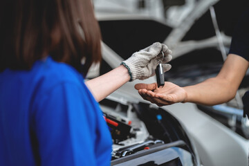 Concept of handover of car keys after inspection and maintenance by professional technicians in car service centers. Car maintenance concept.