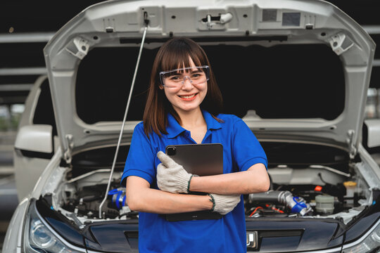 Happy Asian woman expert repairman Auto mechanic in car service in auto garage. Car maintenance concept. Auto mechanic. Auto mechanic.