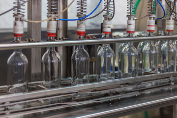 Closeup view of modern vodka bottling line. - obrazy, fototapety, plakaty