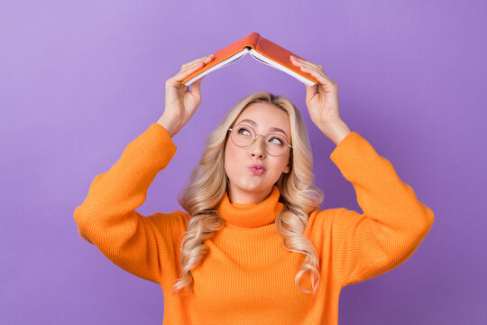 Photo of smart creative person arms hold opened book above head contemplate ponder isolated on violet color background