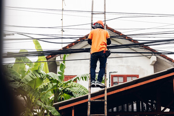 Technician on wooden ladder Checking Fiber Optic Cables. Technician on ladder is check and remove Digital Cable system