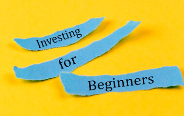 INVESTING FOR BEGINNERS text on a blue pieces of paper on yellow background, business concept