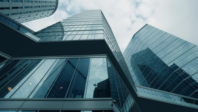Looking up city downtown skyscrapers, modern high-rise office buildings in financial district. Business center architecture, wide angle dolly shot, glass skyscraper view from below, cinematic gimbal