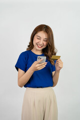 
Cropped view of beautiful asian woman standing holding credit card and smart phone to pay online shopping Attractive woman inserting credit card serial number to pay on internet