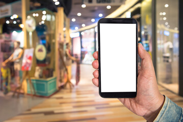 Mock up Blank screen smartphone in shopping mall background of blur background blurred indoors for lifestyle concept or co-working background.