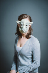 Young woman wearing mask against a grey background in studio. Young woman wearing mask against a grey background in studio.
