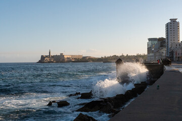 The Malecon waterfront with the three kings castle lighthouse in Havana, Cuba