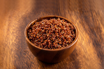 Cooked red quinoa bowl. 45 degrees studio shoot on wooden background.