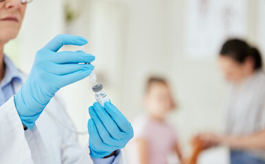 Protection in a vial. Shot of an unrecognizable doctor preparing a vaccine at a hospital.