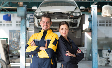 Portrait of engineer and auto mechanic with working on engine repairs in car garages