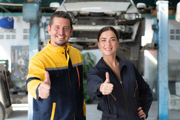 Portrait of engineer and auto mechanic with working on engine repairs in car garages