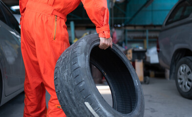 A car mechanic inspects the condition of a car tire before placing it on a vehicle.