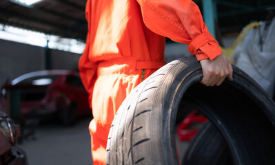 A car mechanic inspects the condition of a car tire before placing it on a vehicle.