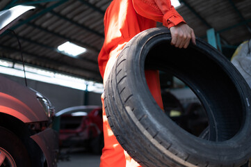 A car mechanic inspects the condition of a car tire before placing it on a vehicle.