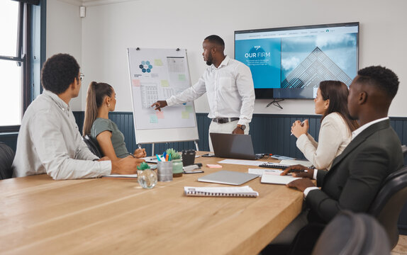 A group of young diverse corporate business people working as a team on a project in a boardroom. African American man speaker using a chart and graph to discuss statistics and planning a strategy