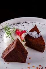 Chocolate Brownie cake with Vanilla Ice Cream on black plate