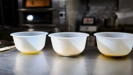 Three containers for kneading dough in the kitchen. Preparation of confectionery products